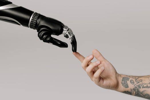 pexels photo 6153354 6153354 A human hand with tattoos reaching out to a robotic hand on a white background.